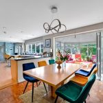 Modern dining room and kitchen with conservatory view.