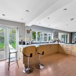Modern kitchen with breakfast bar, garden view.
