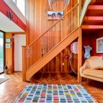 Colourful hallway with wooden staircase and accent wall.
