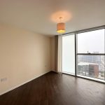 Empty room with large window and city view.