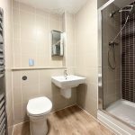 Modern bathroom with shower, toilet and sink.