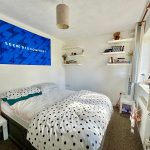 Cosy bedroom with polka dot bedding and wall decor.