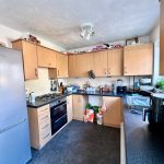 Modern kitchen with wooden cabinets and appliances.