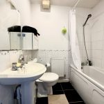 Small bathroom with sink, toilet, and bathtub.