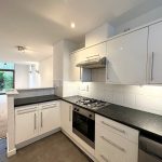Modern kitchen with garden view and sleek design.