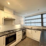 Modern kitchen with oven, cabinets, and washing machine