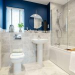 Modern bathroom with blue walls and white fixtures.
