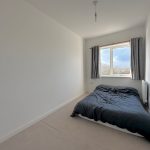 Minimalist bedroom with window and double bed.