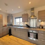 Modern kitchen with wooden cabinets and stainless appliances.