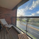 Sunny balcony view with chair and road.