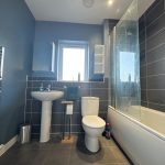 Modern bathroom with grey and blue tiles.