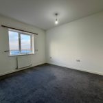 Empty room with carpet and window view.