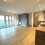 Modern open-plan kitchen with wooden flooring.