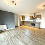 Modern open-plan kitchen with wooden flooring.