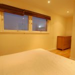 Minimalist bedroom with bed and wooden dresser