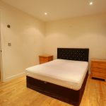 Bedroom with wooden floor and double bed