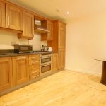 Modern kitchen with wooden cabinets and dining area.