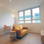 Modern furnished living room with large windows.