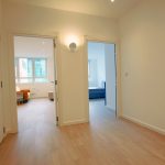 Bright hallway with wooden floors and modern doors.