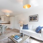 Modern open-plan living area with kitchen and sofa.
