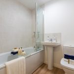 Modern bathroom with bathtub, sink, and toilet.
