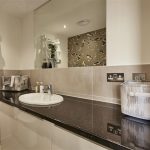 Modern bathroom with black countertop and mirror