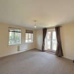Spacious living room with large windows and curtains.