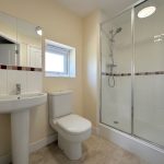 Modern bathroom with shower, sink, and toilet.
