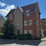 Modern three-storey brick house on sunny street.