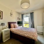 Cosy bedroom with window and pink bedding.