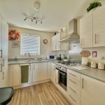 Modern kitchen with white cabinets and appliances.