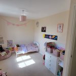 Child's bedroom with toys and bookshelves.