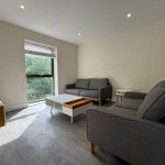 Modern living room with grey sofas and wooden tables.