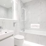 Modern white marble bathroom with bath and vanity.