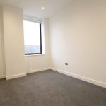 Empty room with grey carpet and white walls.