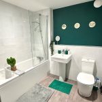 Modern bathroom with green accents and white tiles.