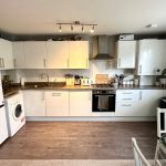 Modern kitchen with appliances and a dining area.