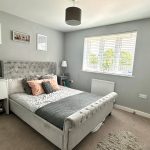 Modern bedroom with grey decor and cosy furnishings.