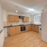 Modern kitchen with wooden cabinets and appliances.