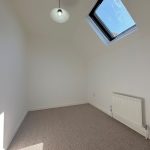 Minimalist room with skylight and radiator.