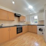 Modern kitchen with appliances and wooden cabinets.