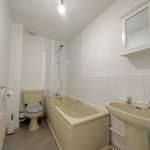 White bathroom with bath, toilet, and sink.