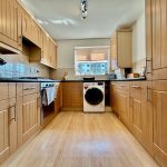 Modern kitchen with wooden cabinets and appliances.