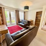 Bright living room with sofas and dining area.