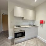 Modern kitchen with cabinets, oven, and sink.