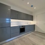 Modern kitchen with grey cabinets and oven.