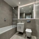 Modern tiled bathroom with bathtub and mirror