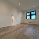 Empty room with wooden floor and window view.