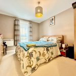 Cosy bedroom with double bed and soft lighting.