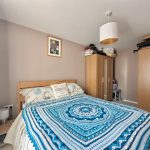 Cosy bedroom with blue patterned bedspread.